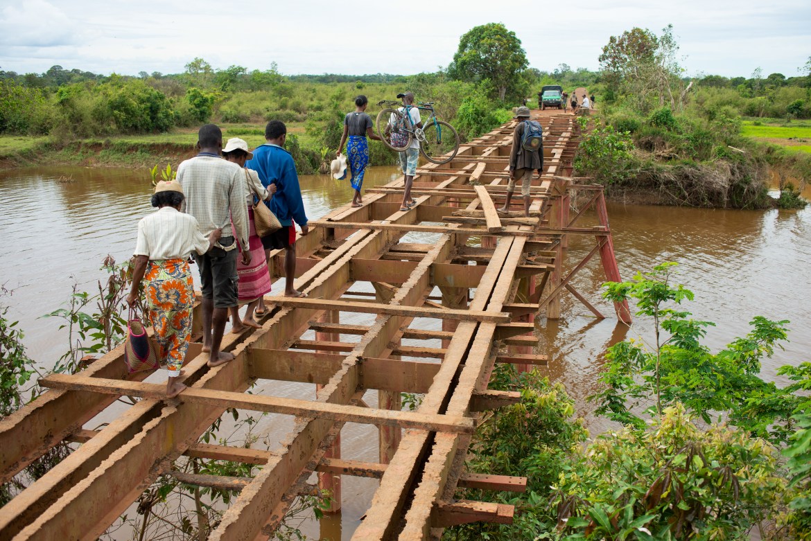 Residents cross a bridge destroyed by Cyclone Batisrai