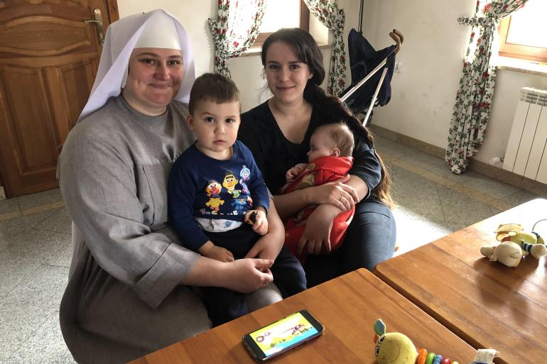 A photo of two women, Diana Oliynyk and Monika Chernyeska, holding two children, Yeva and Marko.