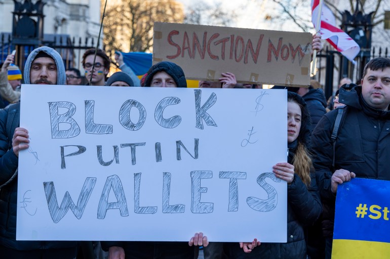 Protester holds banner that reads "Block Putin Wallets"