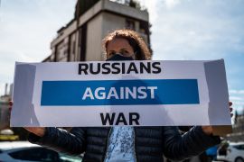 A woman seen with a sign that reads 'Russians against war'