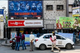 People seen in front of a movie theater that is screening the film Kashmir files that