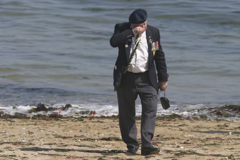 A Canadian D-Day veteran wipes his eyes while visiting Juno beach, France