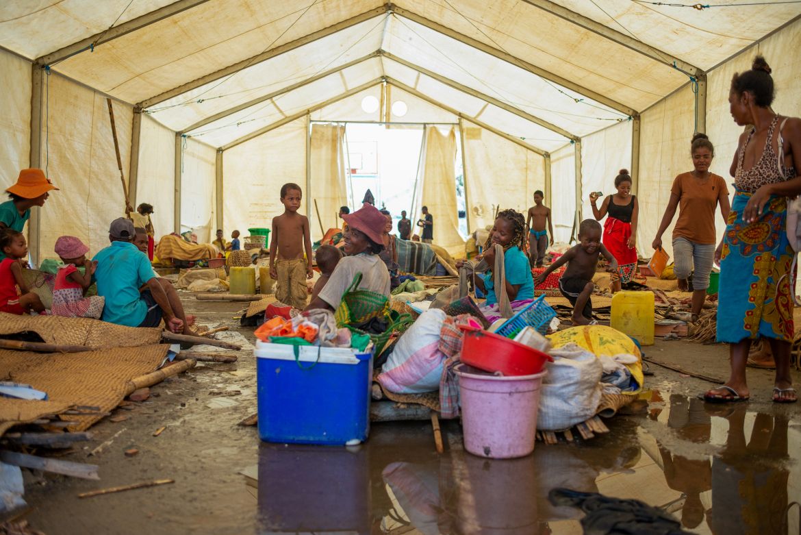 People displaced by Cyclone Batsirai gather in a flooded tent in Mananjary