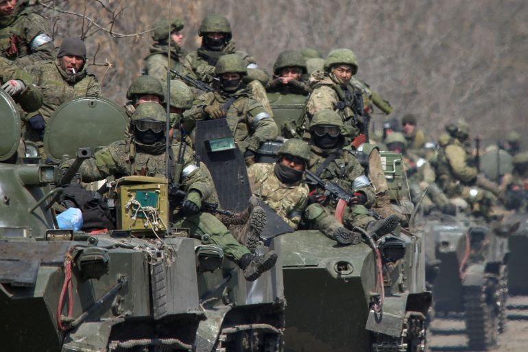 Service members of pro-Russian troops ride on armoured vehicles in Mariupol, Ukraine, April 15, 2022