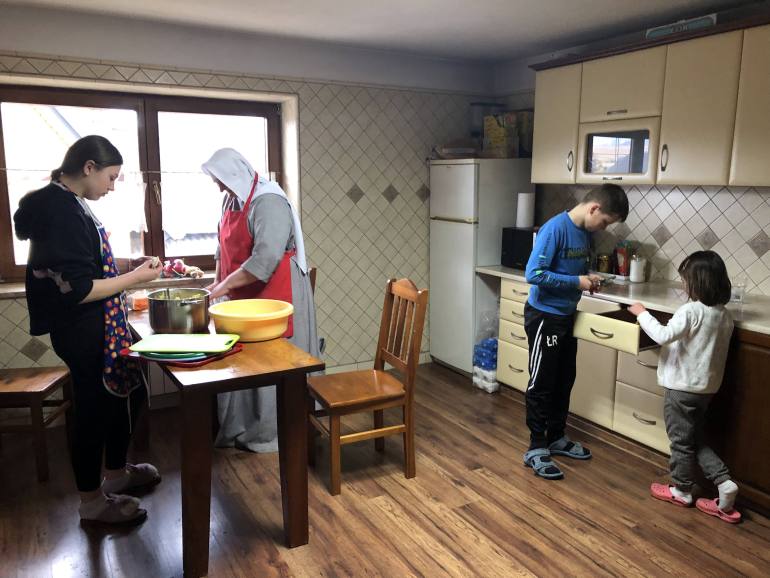 A photo of Monika Chernyeska and children make dinner.