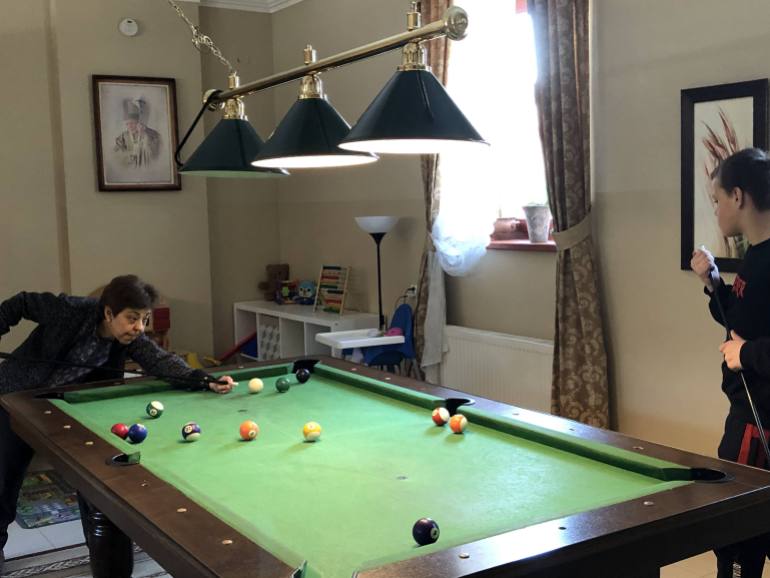 A photo of One of the Grichuk children playing billiards with a volunteer.