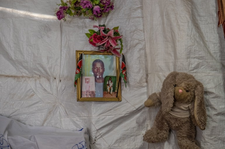 A photo of a photo of Victor Okoth, Benna Buluma's slain son, hanging in Buluma's single-room makeshift home.