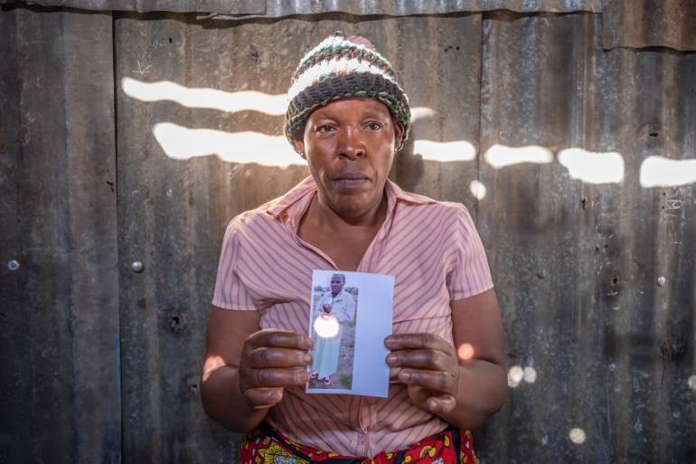 A photo of Fidesia Wamburu Gitau holding a photo of her son Kevin.