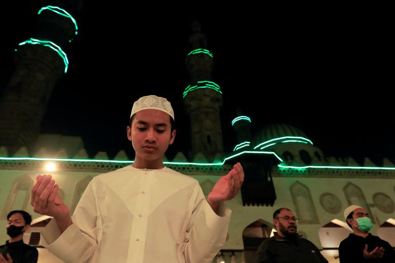 Young man holding a lit candle in Ramadan prayers