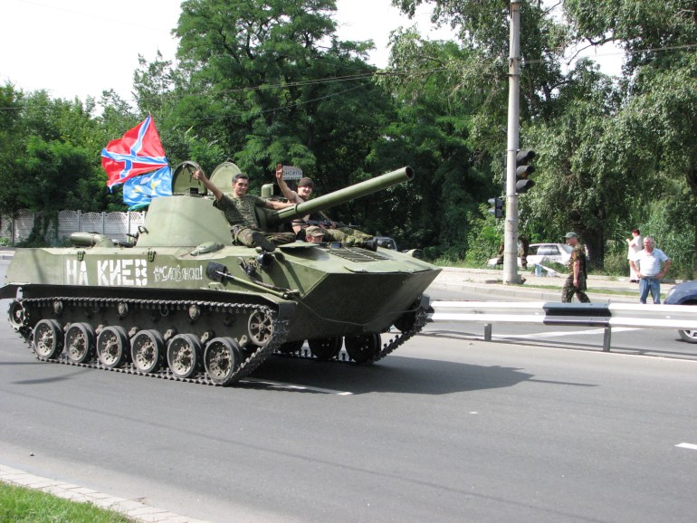 Separatists in a tank. A sign on the left side reads 'To Kyiv'