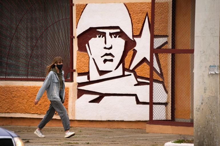 A woman walks past the Operational Group of Russian Forces headquarters in Tiraspol in 2021, the capital of the breakaway region of Transnistria, a disputed territory unrecognised by the international community, in Moldova [File Photo: Dmitri Lovetsky/AP]