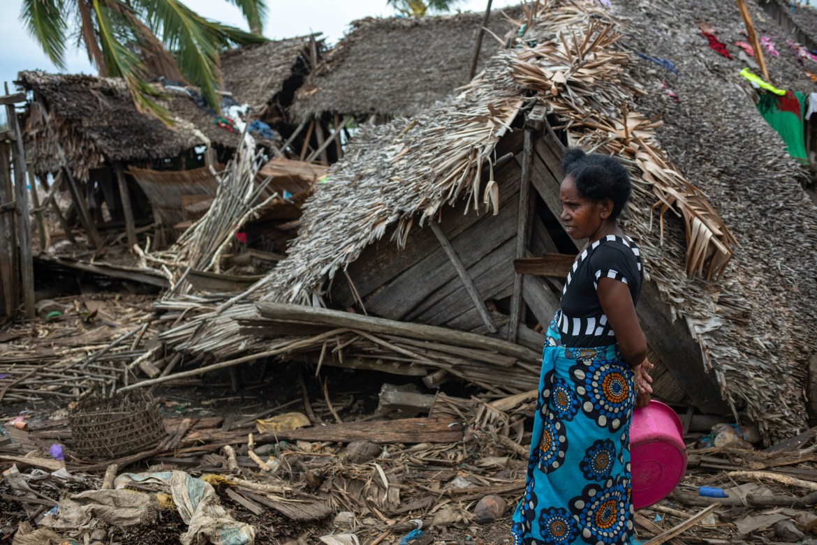 A woman stands next to a structure destroyed by Cyclone Batisrai