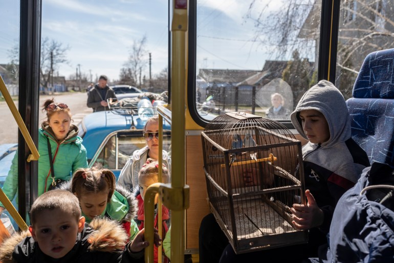10 year-old Roma holds a cage with two parrots inside a bus leaving from the city of Bashtanka , Mikolaiv district, after he and his family fled from Kherson which is occupied by Russian forces.