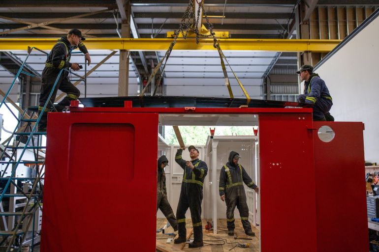 Workers assemble a heavy duty drill shack at a mining equipment manufacturing shop in Parksville, British Columbia