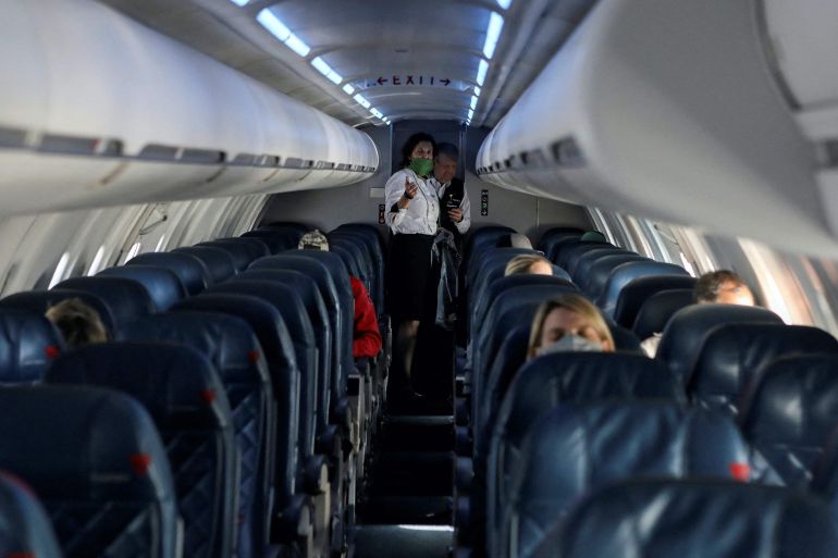 Flight attendants talk on a Delta Airlines flight