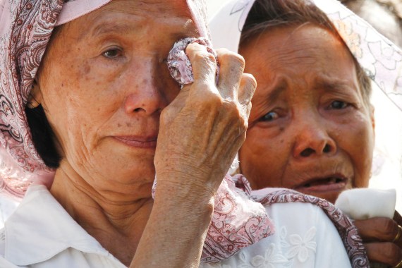 A woman wipes her eyes as another sobs during a ceremony to remember those killed by the Khmer Rouge.