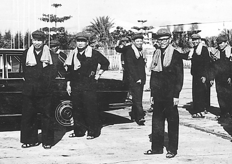 Pol Pot, Noun Chea, Leng Sary, Son Sen and other supporters pictured in Phnom Penh in thir customary black outfits next to a Mercedes Benz during the Khmer Rouge regime