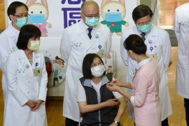 President Tsai Ing wen surrounded by doctors and a nurse in white coats after getting her COVID-19 shot