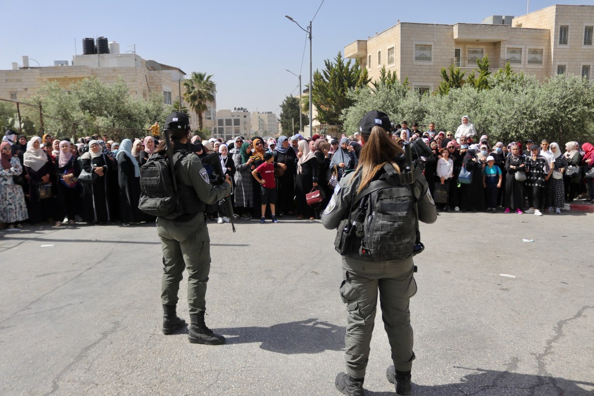 Palestinians wait at the Qalandiya checkpoint to get into Jerusalem