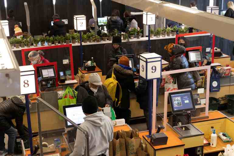 People pay for their purchases at a supermarket in Manhattan, New York City, US