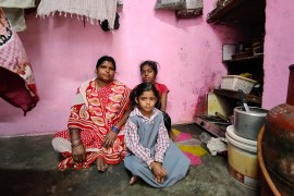 Surya Kali, wife of a casual worker, with her daughters Sunaina, 5, and Swati, 13 at their home in a camp in Delhi, India