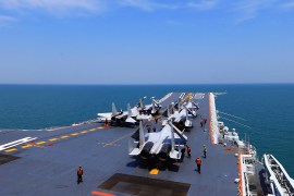Fighter jets lined up on the deck of China's first aircraft carrier while out at sea