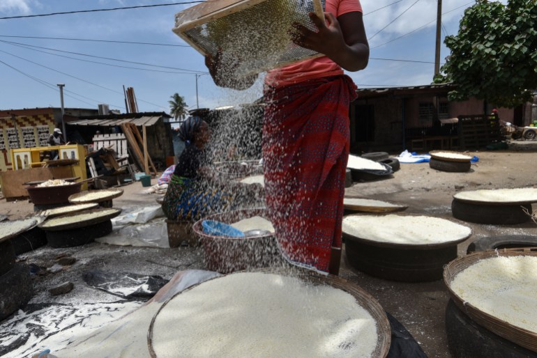 Women sieve cassava (manioc) for the preparation of the attieke side dish in Abidjan