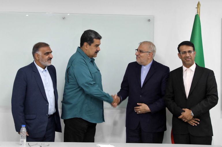 President Nicolas Maduro (2-L) shaking hands with Iran's Oil Minister Javad Owj