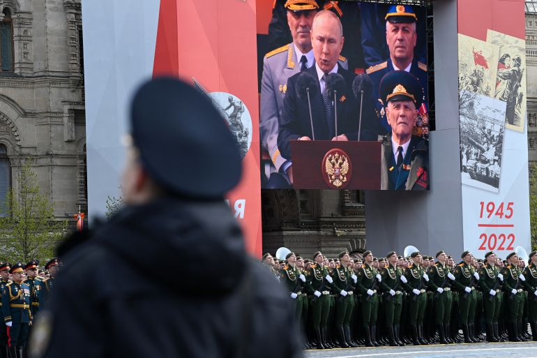 A screen shows Russian President Vladimir Putin giving a speech
