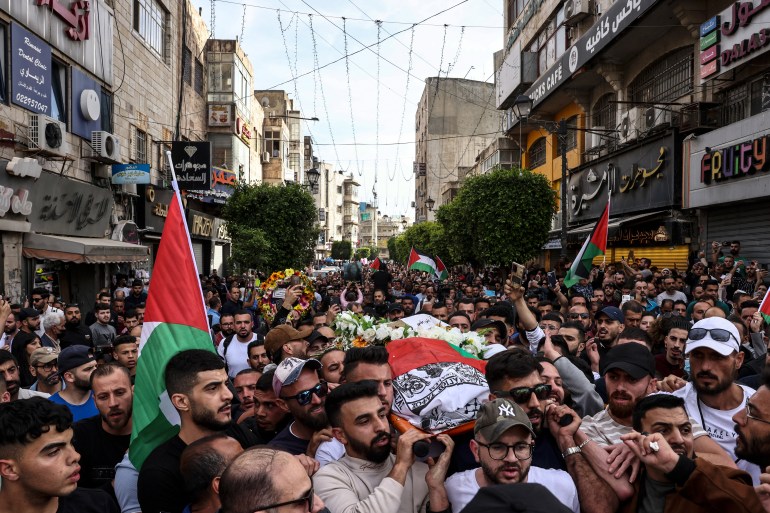 Palestinians carry the flag-draped body of veteran Al-Jazeera journalist Shireen Abu