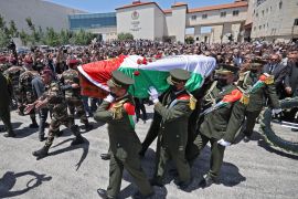Palestinian honour guard carry the coffin of veteran Al Jazeera journalist Shireen Abu Akleh following a state funeral at the presidential headquarters in the occupied West Bank city of Ramallah, on May 12, 2022 [Abbas Momani/AFP] (AFP)