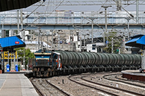A man sitting near a special train carrying water for storage in the underground tanks for the usage by people on a hot summer day in Pali.