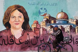 A Palestinian man rides his bicycle in front of a mural painted by an artist in honour of slain veteran Al Jazeera journalist Shireen Abu Akleh, in Gaza City on May 13, 2022 [Mohammed Abed/AFP]