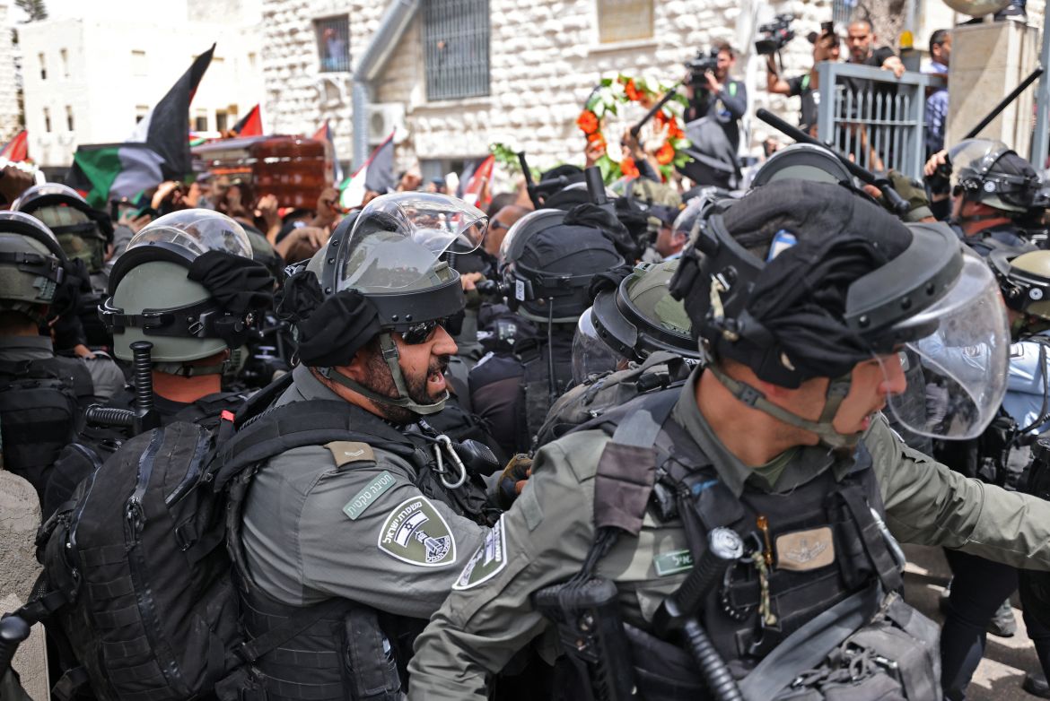 Violence erupts between Israeli security forces and Palestinian mourners carrying the casket of slain Al-Jazeera journalist Shireen Abu Akle out of a hospital, before being transported to a church and then her resting place, in Jerusalem, on May 13, 2022. - Abu Akleh, who was shot dead on May 11, 2022 while covering a raid in the Israeli-occupied West Bank, was among Arab media's most prominent figures and widely hailed for her bravery and professionalism. (Photo by AHMAD GHARABLI / AFP)