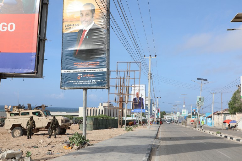 African Union (AU) peacekeepers stand next to election banners of presidential candidates along a street in Mogadishu