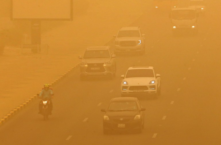 Des voitures roulent au milieu d'une forte tempête de sable à Koweït le 16 mai 2022. 