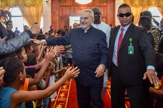 East Timor president Jose Ramos Horta greets a group of chidren who are waiting to meet him, hands outstretched