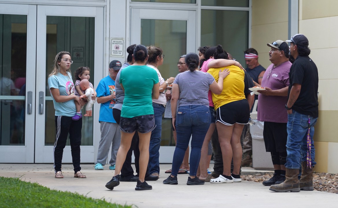 Families gather and hug outside the Willie de Leon Civic Center where grief counseling will be offered in Uvalde