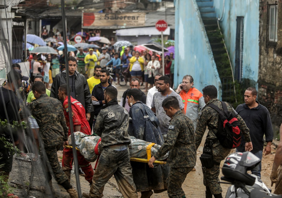 This handout picture release by the Recife City Hall shows rescue workers removing the corpse of a victim from a highly populated area destroyed by a landslide in the community Jardim Monte Verde, Ibura neighbourhood, in Recife, Pernambuco State, Brazil, on May 28, 2022. - Torrential rains that have plagued Brazil's northeastern Pernambuco state since Tuesday have left at least 34 dead, 29 of which occurred over the last 24 hours, according to the latest official update. (Photo by Diego NIGRO / RECIFE CITY HALL / AFP) / RESTRICTED TO EDITORIAL USE - MANDATORY CREDIT "AFP PHOTO / RACIFE CITY HALL / DIEGO NIGRO" - NO MARKETING - NO ADVERTISING CAMPAIGNS - DISTRIBUTED AS A SERVICE TO CLIENTS
