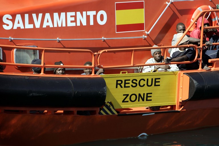 Migrants sit aboard a Coast Guard vessel after arriving at Spain's island of Fuerteventura
