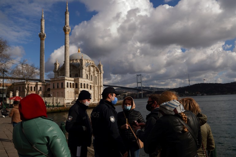 Turkish police officers check the passports of a group of Russian tourists in Istanbul
