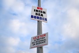 Signs reading 'No Irish Sea border' and 'Ulster is British, no internal UK Border' are seen affixed to a lamp post at the Port of Larne, Northern Ireland.