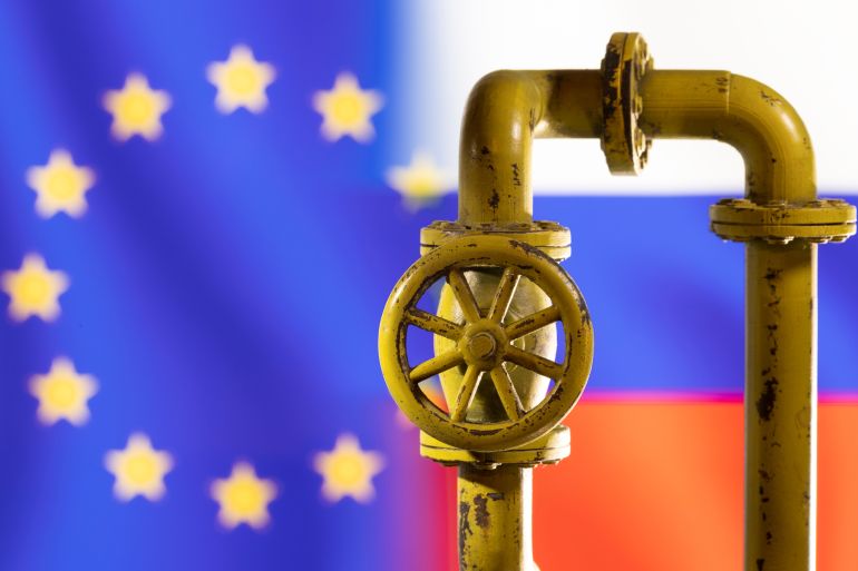 A model of the natural gas pipeline is seen in front of displayed word EU and Russia flag colours in this illustration