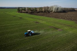 An aerial view shows a tractor spreading fertiliser on a wheat field near the village of Yakovlivka after it was hit by an aerial bombardment outside Kharkiv, as Russia&#39;s attack on Ukraine continues [File: Thomas Peter/Reuters]