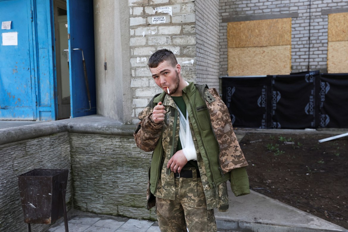 An injured soldier smokes a cigarette outside the hospital amid Russia's invasion of Ukraine in Kramatorsk, Ukraine