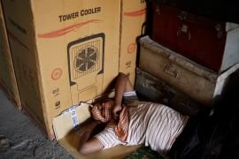 A labourer sleeps at an air cooler market on a hot summer day in New Delhi