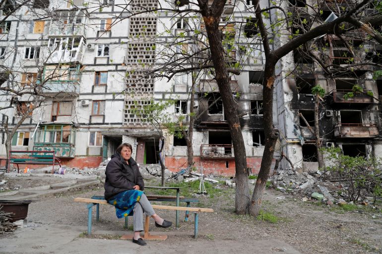 Local resident Tatiana Bushlanova, 64, sits on a bench near an apartment building heavily damaged during Ukraine-Russia conflict in the southern port city of Mariupol, Ukraine May 2, 2022. REUTERS/Alexander Ermochenko