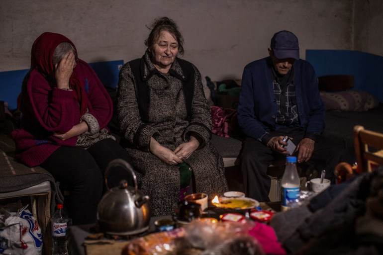 People take shelter in a basement in Marinka, using candles for light. as Russia turns its firepower on Donetsk