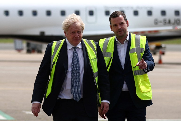 British Prime Minister Boris Johnson speaks with MP for Eastleigh Paul Holmes on the tarmac of Southampton Airport
