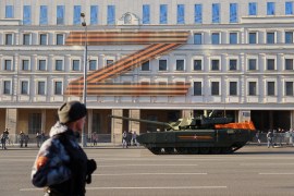Russian service members drive a tank along a street during a rehearsal for the Victory Day military parade